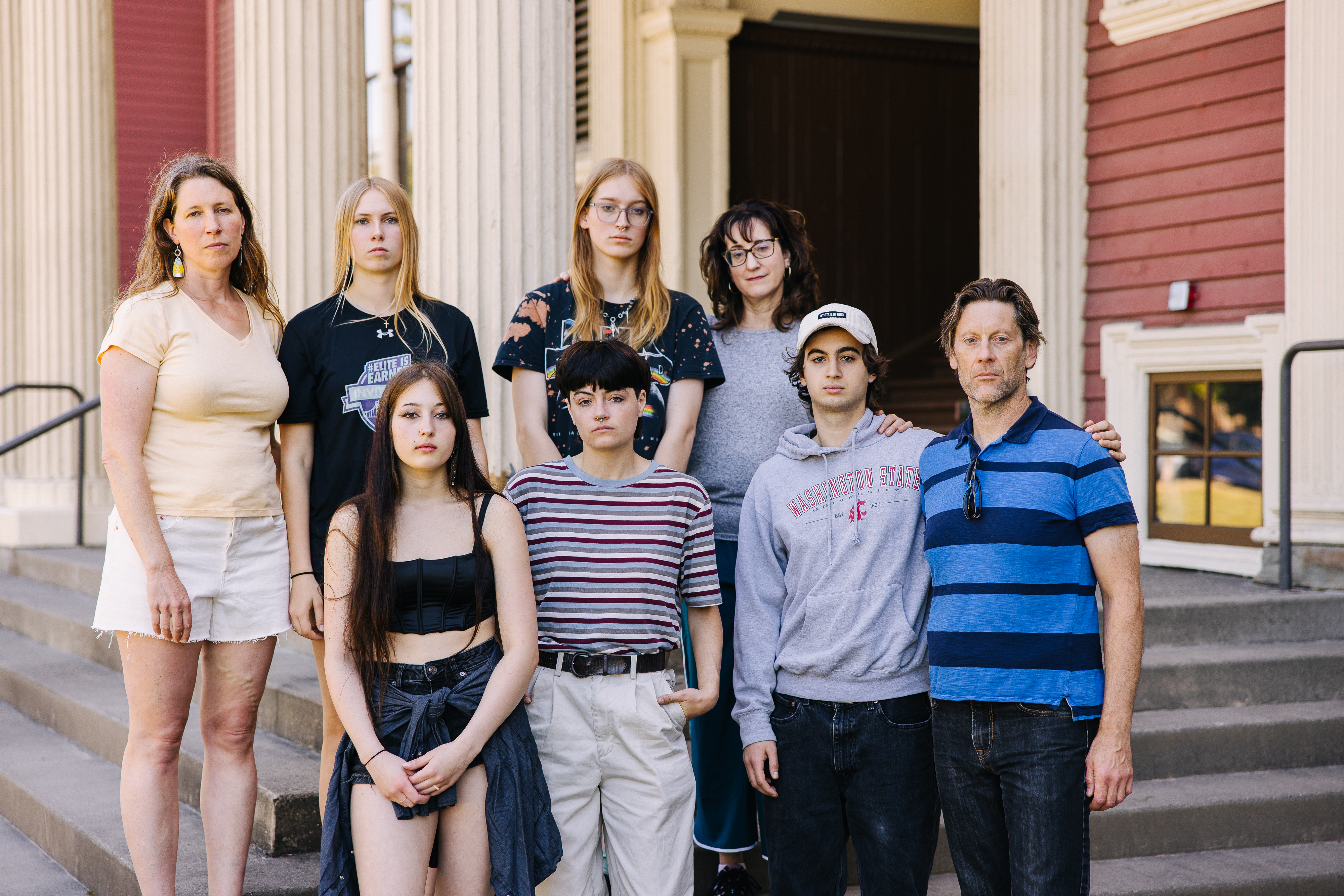 a multigenerational group stands looking serious