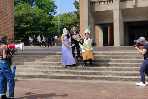 A mock wedding of the UW and Starbucks is officiated by an actor playing UW President Ana Marie Cauce