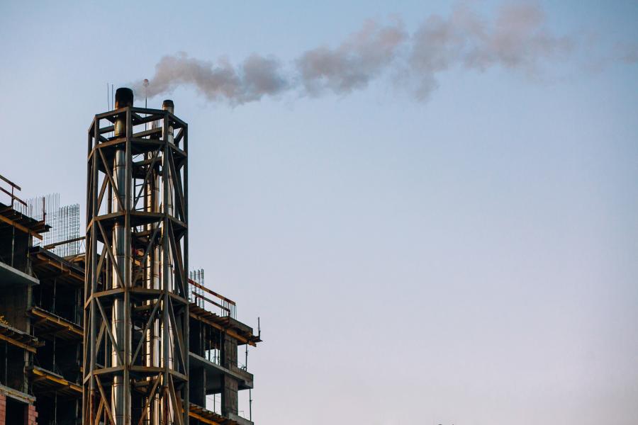 An oil refinery smokestack spews pollution into the air