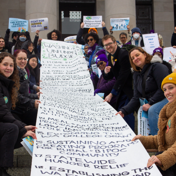 Advocates hold a giant banner of the "unfunded budget" on the Washington State Legislature's steps.